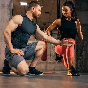 A personal trainer working with a client, providing personalized fitness instruction in miami beach gym