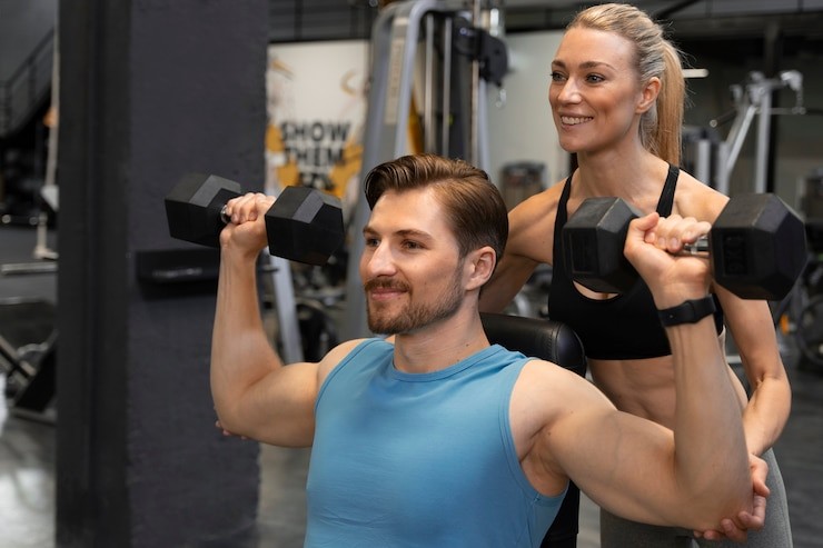 trainer-helping-beginner-gym
